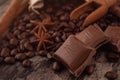 Chocolate, cinnamon sticks  and coffee beans on wooden background Royalty Free Stock Photo