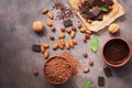 Chocolate, cocoa powder, a variety of nuts and mint leaves on a dark brown rustic background. View from above,flat lay Royalty Free Stock Photo