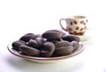 chocolate coffee beans in a mug on a saucer, white background Royalty Free Stock Photo