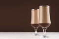 Chocolate and coffee dessert in two elegant transparent glass  in modern dark brown kitchen interior, copy space. Royalty Free Stock Photo