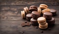 Chocolate and coffee macaroons or macarons on old dark brown wooden background