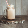 Chocolate coffee milkshake with whipped cream served in glass mason jar on gray wooden background. Summer drink. Square image. Royalty Free Stock Photo