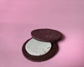 Chocolate cookie filled with cream on pink background. desserts concept