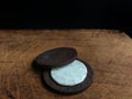 Chocolate cookie filled with cream on wooden board with black background. desserts concept