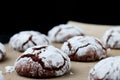 Chocolate cookies with cracks on baking paper and iolated on black. Cracked chocolate biscuits Royalty Free Stock Photo