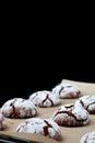 Chocolate cookies with cracks on baking paper and iolated on black. Cracked chocolate biscuits Royalty Free Stock Photo