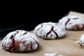 Chocolate cookies with cracks on baking paper and iolated on black. Cracked chocolate biscuits Royalty Free Stock Photo