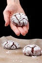 Chocolate cookies with cracks on baking paper and iolated on black. Cracked chocolate biscuits Royalty Free Stock Photo