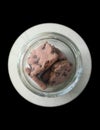 Chocolate cookies in a glass jar isolated from black round vignettes frame, food photography