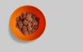 Chocolate cornflakes dipped in chocolate milk in a white bowl in light background with spoon Royalty Free Stock Photo