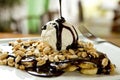 Chocolate crepe and vanilla ice cream, banana and peanuts toppings, French cuisine