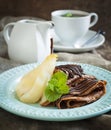 Chocolate crepes with poached pear in syrup Royalty Free Stock Photo