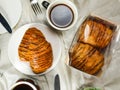 Chocolate Croissant served on plate with cup of black coffee with knife and fork isolated on napkin top view of french breakfast Royalty Free Stock Photo