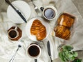 Chocolate Croissant served on plate with cup of black coffee with knife and fork isolated on napkin top view of french breakfast Royalty Free Stock Photo