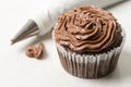 Chocolate cup cake with piping bag on the white marble background Royalty Free Stock Photo