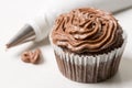 Chocolate cup cake with piping bag on the white marble background Royalty Free Stock Photo