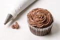 Chocolate cup cake with piping bag on the white marble background Royalty Free Stock Photo