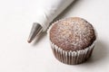 Chocolate cup cake with piping bag on the white marble background Royalty Free Stock Photo