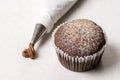 Chocolate cup cake with piping bag on the white marble background Royalty Free Stock Photo