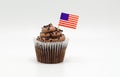 Chocolate cupcake with an American flag toothpick in it isolated on white