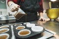 Chocolate cupcake batter. Unrecognizable caucasian pastry chef pouring batter into paper muffin mould in muffin liner. Royalty Free Stock Photo