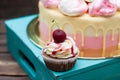 Chocolate cupcake with berry sauce, whipped cream and fresh cherry on top. Cake on the background Royalty Free Stock Photo