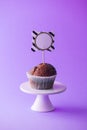 Chocolate cupcake with empty topper label, purple background