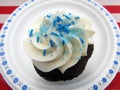 Chocolate cupcake with white frosting and blue sprinkles Royalty Free Stock Photo