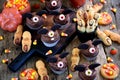 Chocolate cupcakes `bats` and shortbread cookies `witch`s fingers` - delicious bakery sweets for the celebration of Halloween. Royalty Free Stock Photo