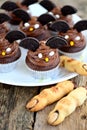 Chocolate cupcakes `bats` and shortbread cookies `witch`s fingers` - delicious bakery sweets for the celebration of Halloween. Royalty Free Stock Photo