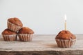 Chocolate cupcakes with candle on wooden table. Copy, empty space for text