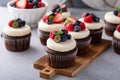 Chocolate cupcakes with cream cheese frosting and fresh berries Royalty Free Stock Photo