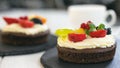 Chocolate cupcakes with cream cheese, fruits and berries. Mini cake as healthy coffee dessert. Closeup, selective focus Royalty Free Stock Photo