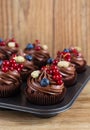Chocolate cupcakes decorated with chocolate cream and summer berries Royalty Free Stock Photo