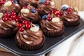 Chocolate cupcakes decorated with chocolate cream and summer berries Royalty Free Stock Photo