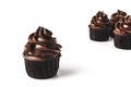 Chocolate cupcakes with gold sparkles sprinkled on chocolate icing on isolated white background. Mockup for your design