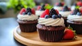 chocolate cupcakes with icing and fresh berries