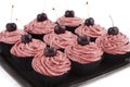 Chocolate cupcakes, with red frosting and a cherry