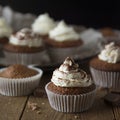 Chocolate cupcakes with whipped cream on rustic wooden table. Homemade dessert. Square image