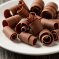Chocolate curls are arranged on a white plate. These dark brown curls are made from thin, rolled Royalty Free Stock Photo