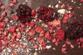 Textured background of artistically decorated chocolate bar with berries and pieces of nuts