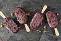 Chocolate dipped ice cream bars scattered on dark slate background