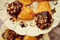 Chocolate dipped madeleines on three tier dessert display plates