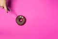 Chocolate donut with eyes, female hand slicing donut knife, top view Royalty Free Stock Photo