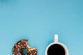 Chocolate donuts with coffee on the blue background.