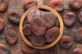 Chocolate dried apricots in wooden bowl, top view