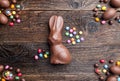 Chocolate Easter bunny, eggs and sweets on rustic background