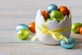 Chocolate easter egg in eggshell shaped bowl on light wooden background, easter sweets, decoration Royalty Free Stock Photo