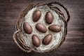 Chocolate Easter eggs in a basket on wooden background Royalty Free Stock Photo