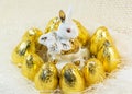 Chocolate Easter eggs in bright golden cover and porcelain rabbit